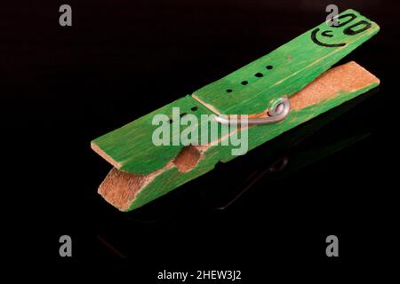 green colored  clothespin with smiley on it Stock Photo