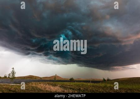 Dark, dramatic clouds and sky ahead of a severe storm over a lake in North Dakota, USA Stock Photo
