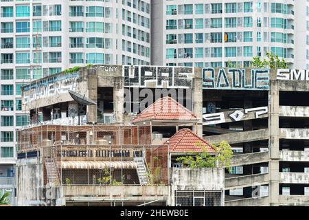 Graffiti on the car park building of the unfinished Sathon Unique Tower in Bangkok Thailand. The building has been left unfinished after the Asian fin Stock Photo