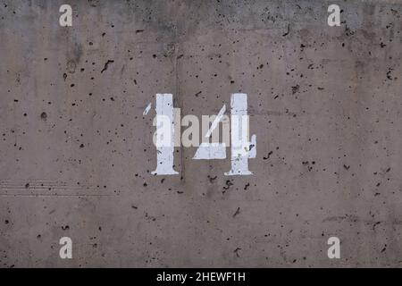 polished, stippled and weathered concrete wall with the number 14 Stock Photo