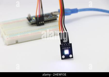 ARGB LED module connected to the breadboard using jumper wires, Various electronic parts combined to make amazing science projects Stock Photo