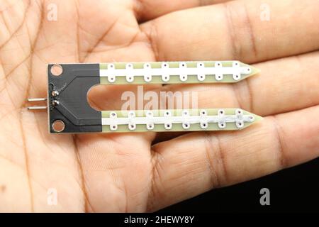 Close up of soil moisture sensor held in hand, Electronic sensor boards for prototyping innovative projects Stock Photo