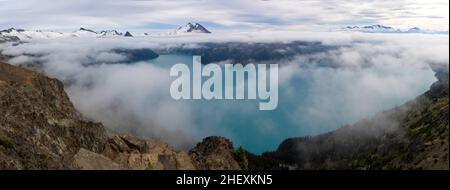 Beautiful view of Garibaldi Lake from Panorama Ridge hike in British Columbia, Canada. Mountains and glaciers peeking through the clouds in the backgr Stock Photo