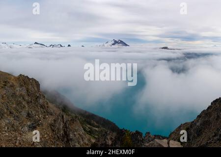 Beautiful view of Garibaldi Lake from Panorama Ridge hike in British Columbia, Canada. Mountains and glaciers peeking through the clouds in the backgr Stock Photo