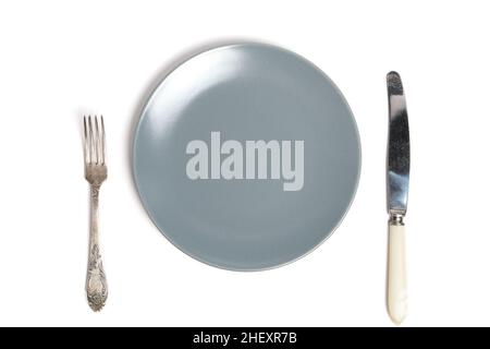 Empty grey plate and cutlery fork and knife white background Stock Photo