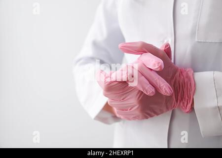 Female doctor in rubber gloves on grey background, closeup Stock Photo