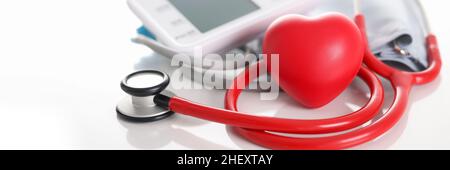 Automatic tonometer stethoscope and red small heart on table Stock Photo