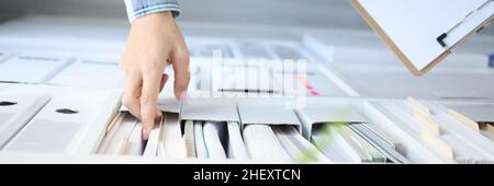 Woman takes out business documents from cabinet closeup Stock Photo
