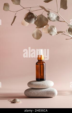 dark amber glass bottle with oil on natural stone with leaf on beige background. natural cosmetics product, beauty and presentation concept , mock up Stock Photo