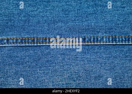 Close-up of blue jeans texture with straight seam. Denim textile background. Clothes fabric. Stock Photo
