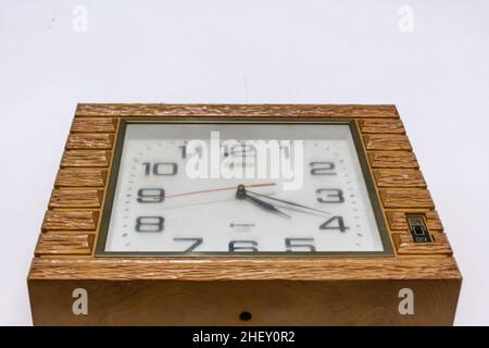 vintage and retro wooden brown clock hanging on the white wall Stock Photo