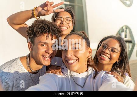 Group of happy teenage friends taking a selfie looking to the camera. Selfie group portrait. Stock Photo