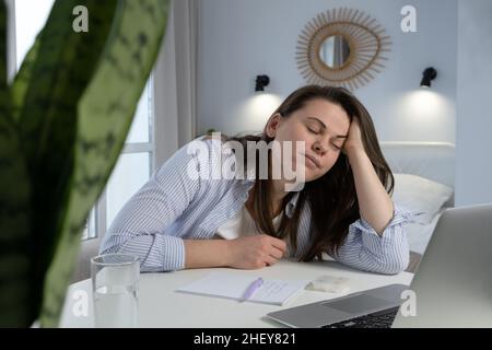 Tired woman sleeps on her working place. Professional burnout, fatigue and sleep disorder concept Stock Photo