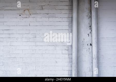 two of water pipes on the vintage rough white wall brick texture arranged background. Suitable for aesthetic wallpaper Stock Photo