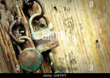 Two old padlocks on an old wooden door Stock Photo
