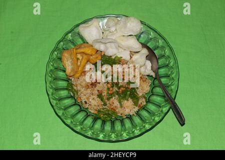 special fried rice with tofu, crackers, fried soybeans, and spring onions isolated on green background Stock Photo