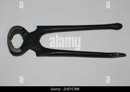 Closeup of pincers with a black handle made of galvanized iron on isolated white background Stock Photo