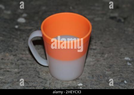 Close up of orange and white plastic cups that are usually used by children. Stock Photo