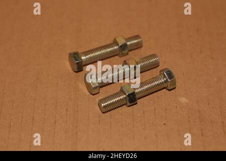 Bolts and nuts isolated on a brown background Stock Photo