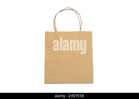 Paper shopping bag with handle isolated cutout on white background. Brown color Kraft package for present and carry goods. Stock Photo