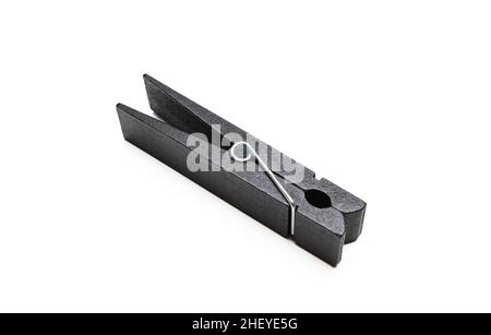 Cloth pin for laundry isolated on white background. Black color wood clothespin, laundry dry peg or office paper clip closeup view. Stock Photo