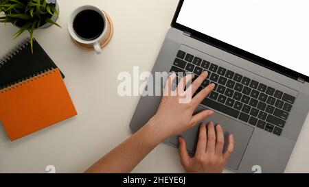 Top view of a female's hands typing on modern notebook laptop computer keyboard on her office desk. Stock Photo