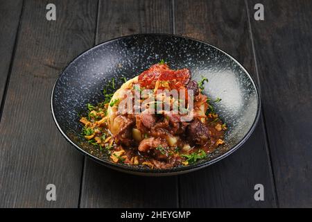 Beef goulash with bacon and mashed potato on a table Stock Photo