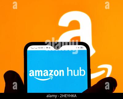 In this photo illustration, the Amazon Hub logo is seen displayed on a smartphone screen and Amazon logo in the background. Stock Photo