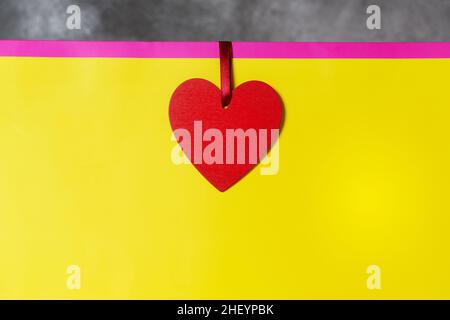Valentines day present mockup in bright colors pink and yellow with red heart-shaped tag Stock Photo