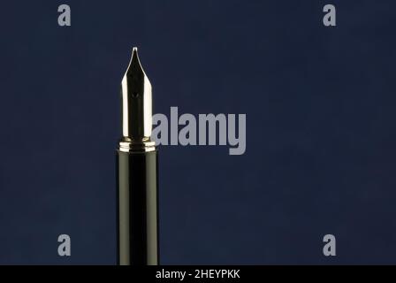 Upright fountain pen isolated on a blue background Stock Photo
