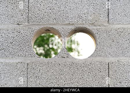 Holes for ventilation pipes in the wall. recuperator hvac installation. Hole in the concrete wall. Close up side view. Stock Photo