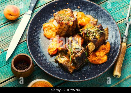 Beef meat roasted in apricots on the plate. Appetizing beef ribs Stock Photo