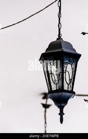 black vintage and classic metal ornament lamp hanging on the white ceiling Stock Photo