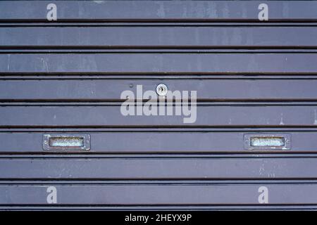 Black steel iron rolling door pattern with the key hole for industrial background and wallpaper Stock Photo