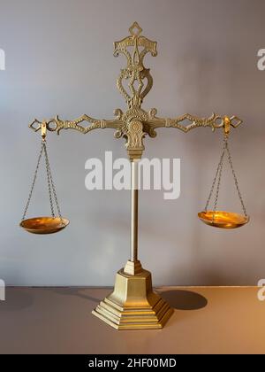 Old fashioned brass weight, gold colored. Justice concept. Stock Photo