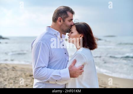 Mature happy loving couple kissing on the sea beach. Stock Photo