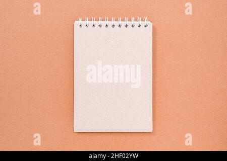 Blank spiral bound notepad on the cardboard background. Copy space. Stock Photo