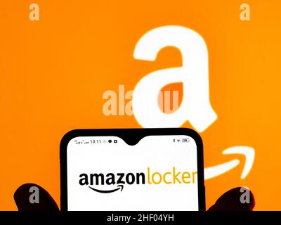 In this photo illustration, the Amazon Locker logo is seen displayed on a smartphone screen and Amazon logo in the background. Stock Photo