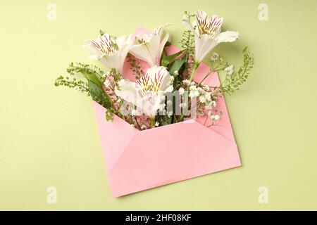Pink envelope with flowers on green background Stock Photo