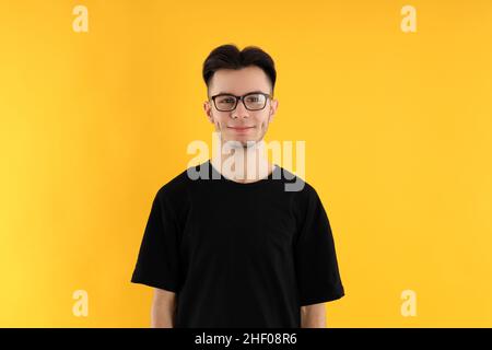 Young man in glasses on yellow background Stock Photo