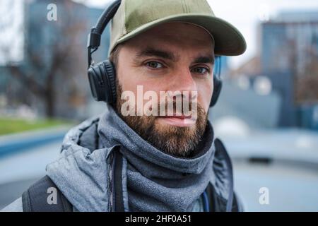 Portrait of young man with headphones listening music outdoors Stock Photo