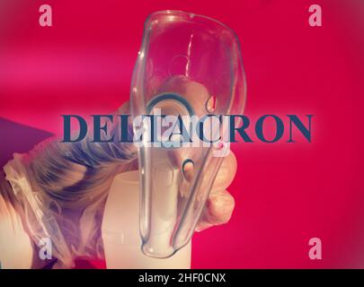 Close up of a doctor hand holding a Cpap mask with the text 'Deltacron' new Covid-19 variant. Stock Photo