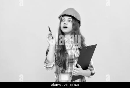 concentrated child worker wear hardhat hold clipboard. childhood development. Stock Photo