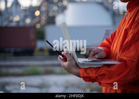 Petrochemical engineers work heavily with radio and laptop in the oil and gas industry. Stock Photo