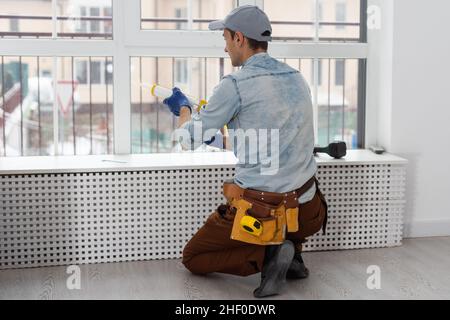 handsome young man installing bay window in a new house construction site. Stock Photo