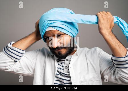 indian sikh man wearing treditional turban at grey background - concept of religion custume and identity. Stock Photo