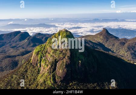 Adam's Peak is a 2243 m tall conical mountain located in central Sri Lanka - Sacred Mountain for four religions with a temple on the top. Aerial flyin Stock Photo