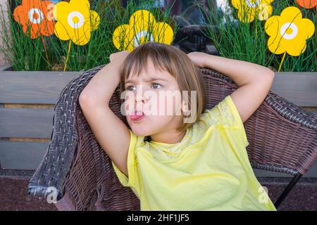 The little girl in cafe puts out the tongue Stock Photo