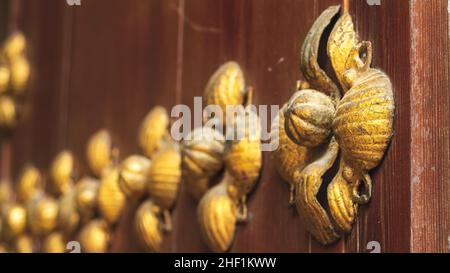 Detalle floral dorado de una puerta antigua de madera en Córdoba, España Stock Photo