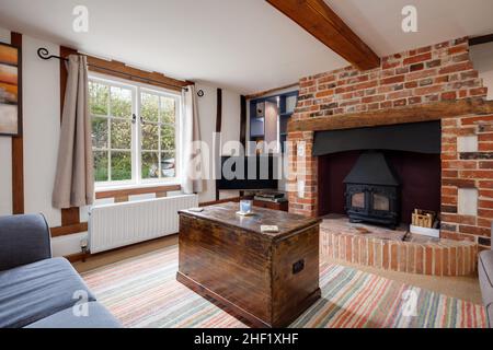Clare, Suffolk - 27 April 2018: Beautiful, charming, small traditional cottage living room with inglenook fireplace and wooden floorboards Stock Photo